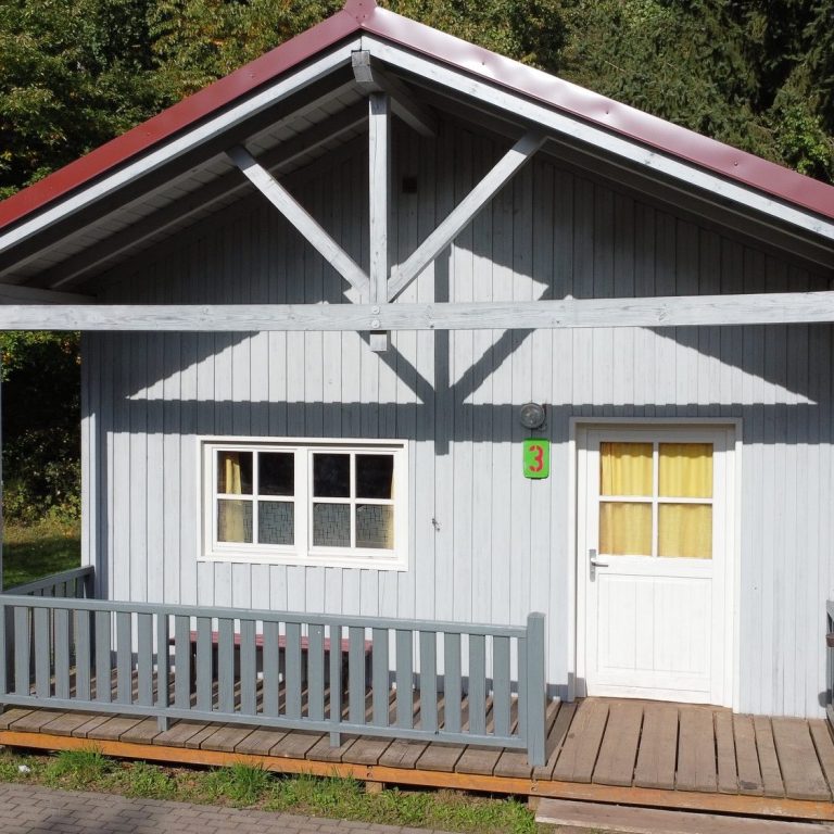 Blockhütte im Ökodorf Graue Blockhütte mit rotem Dach im Ökodorf Losheim am See